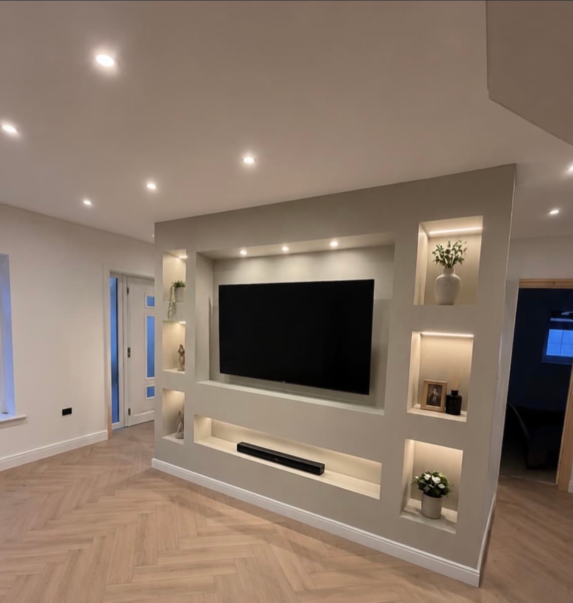 Bespoke media wall with lit display niches and herringbone floor