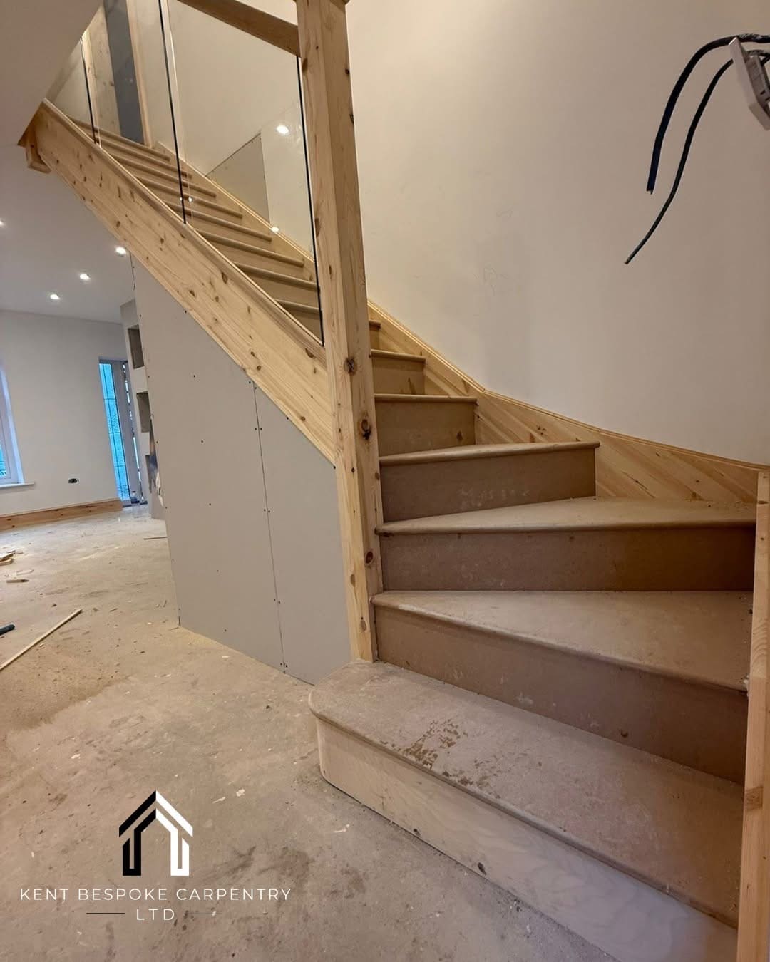 Softwood staircase with glass balustrade, mid-installation